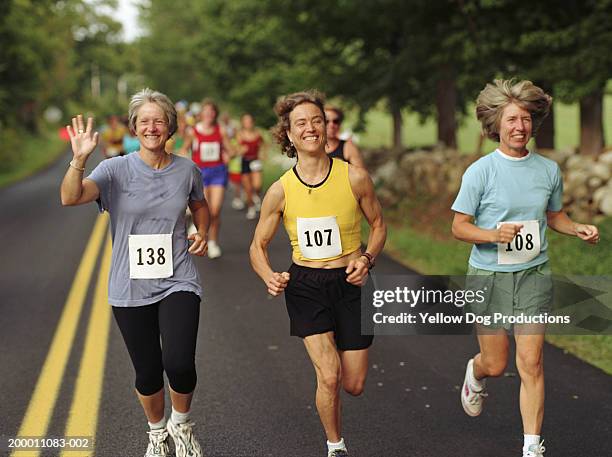 three happy women running in road race - number 50 imagens e fotografias de stock