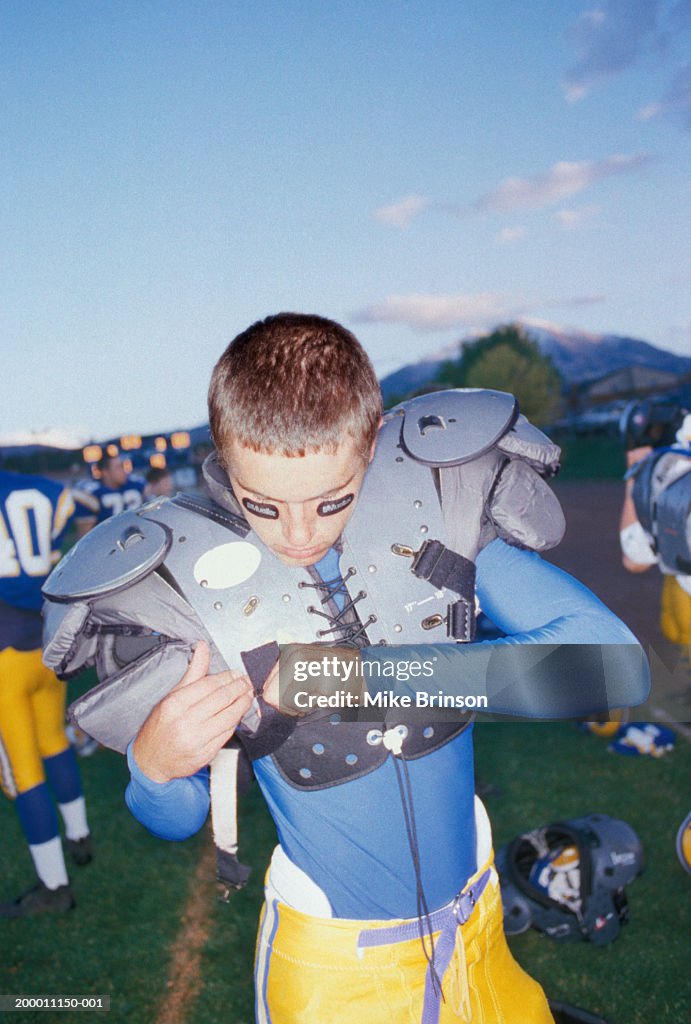 Glimlach Varen ontspannen High School Football Player Securing Shoulder Pads High-Res Stock Photo -  Getty Images
