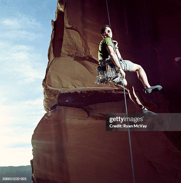 male rock climber rappelling, low angle view, moab, utah, usa - rappelling stock pictures, royalty-free photos & images