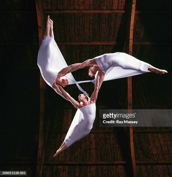 three women suspended from ceiling linking arms, view from below - match sport stockfoto's en -beelden