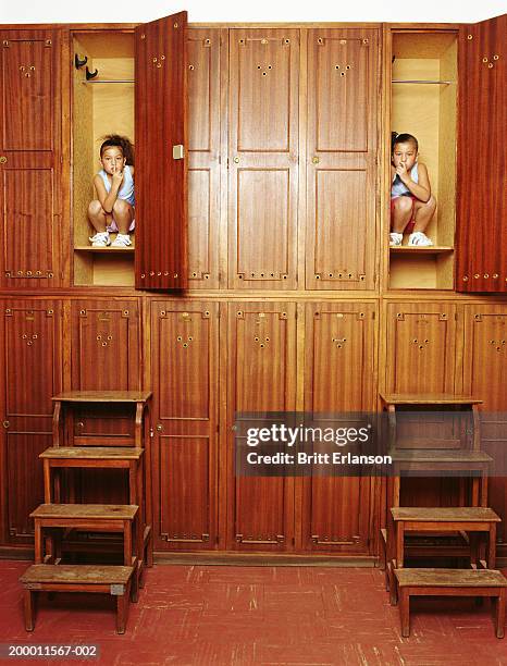 twin girls (6-8) hiding in lockers, portrait - inside locker stock pictures, royalty-free photos & images