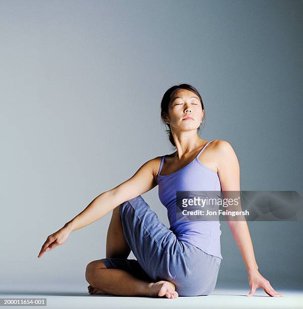 woman in yoga stretch position - yoga studio stock-fotos und bilder