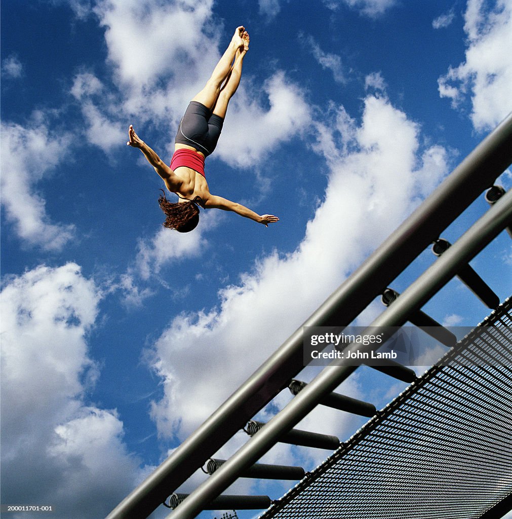 Female trampolinist in mid air, low angle view