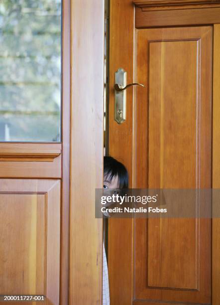 toddler girl (18-21 months) peeking around door - front door open stock pictures, royalty-free photos & images
