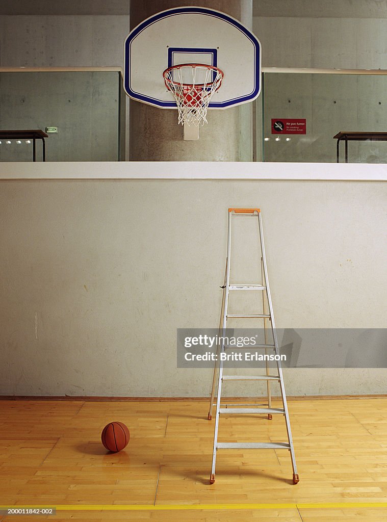 Abandoned step ladder and basketball in sports hall