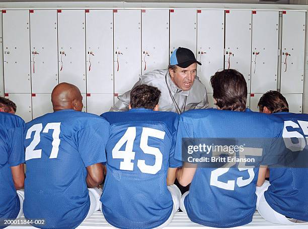 coach shouting at american football players in locker room - american football coach stock-fotos und bilder