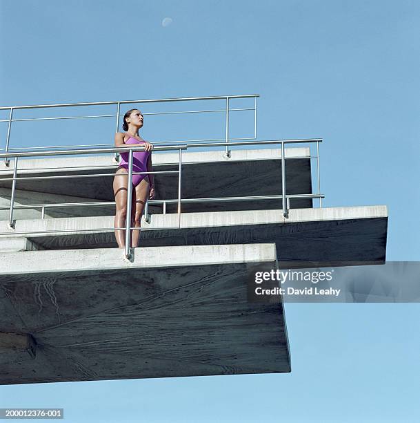 female swimmer on diving board, low angle view - hopptorn bildbanksfoton och bilder