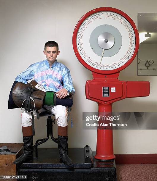 teenage jockey (16-18) with  equipment weighing in, portrait - racing silks stock-fotos und bilder