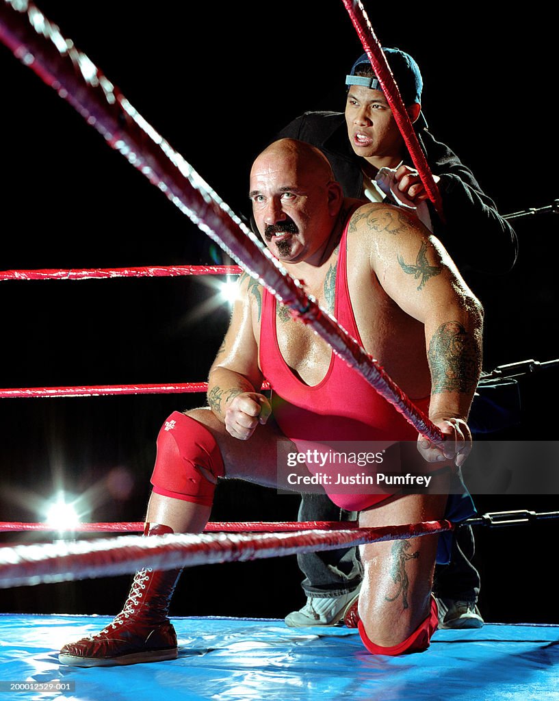 Male wrestler and assistant in corner of ring