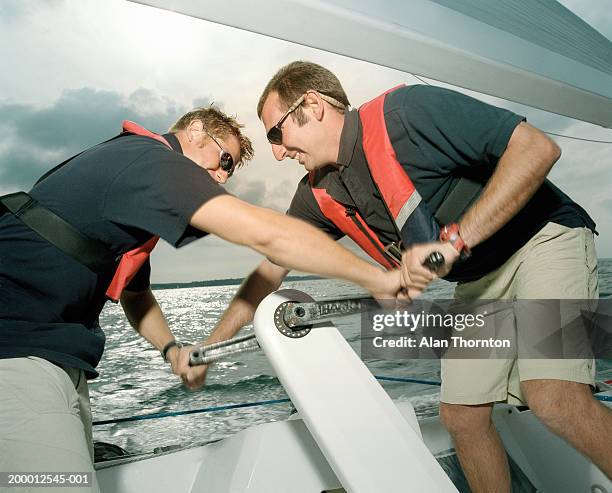 two men tacking yacht, close-up - sailing tacking stockfoto's en -beelden