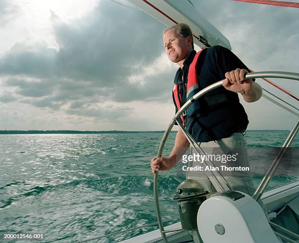 man at helm of yacht - one man only imagens e fotografias de stock
