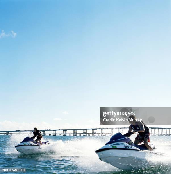 young couple riding jet boats - jet ski - fotografias e filmes do acervo