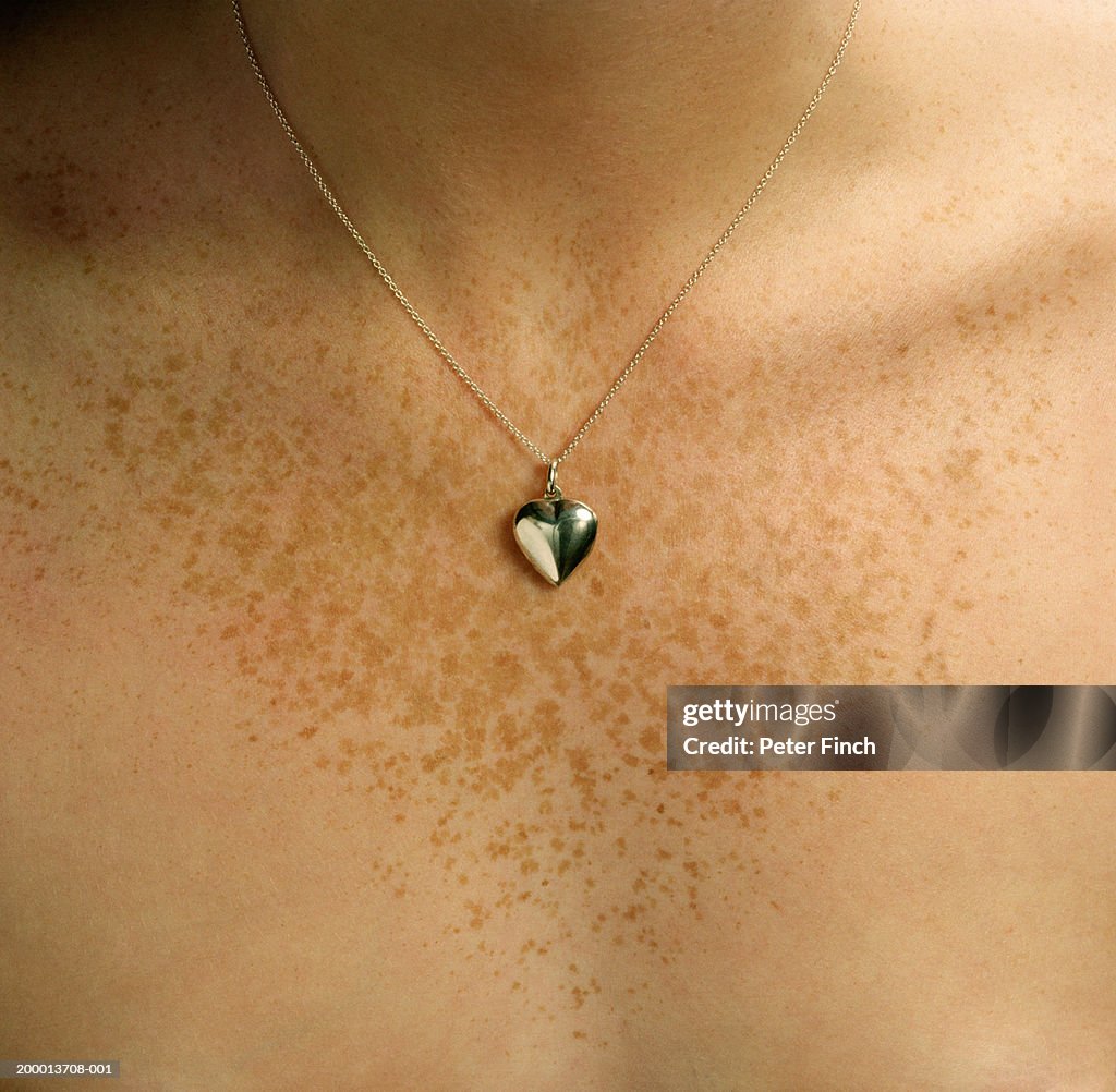 Heart shaped locket around young woman's neck, close-up