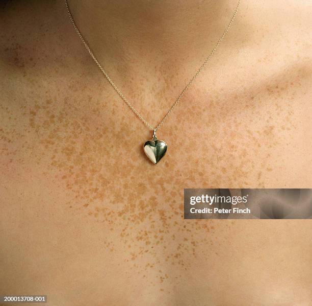 heart shaped locket around young woman's neck, close-up - hangers stockfoto's en -beelden