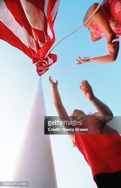 two girls (8-10) raising american flag, low angle view - 9 11 flag 個照片及圖片檔