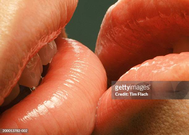 couple with glossy lips kissing, close-up - tim flach stock-fotos und bilder