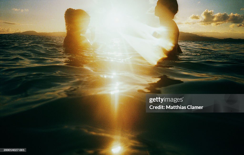 Sunlight shining between two women in water