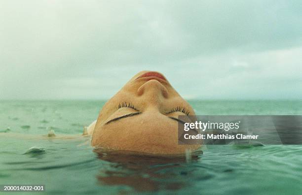 woman lying on back face up in water - floating head stock pictures, royalty-free photos & images
