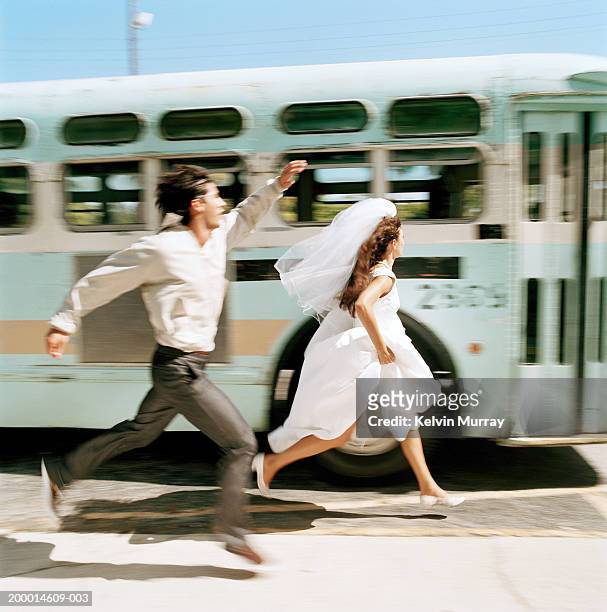bride and young man running to catch bus (blurred motion) - couple run ストックフォトと画像