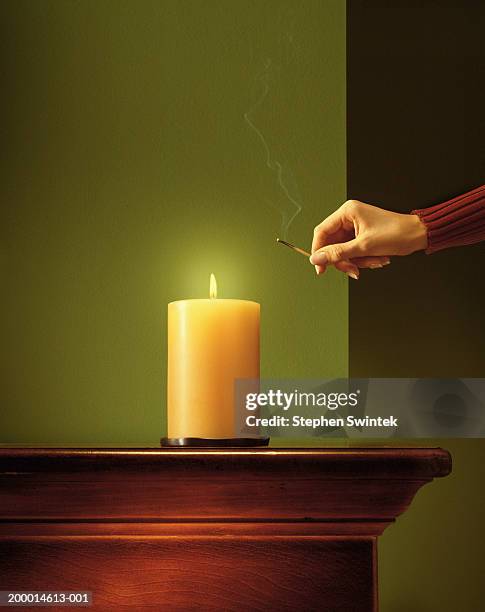 woman lighting candle with match - igniting photos et images de collection