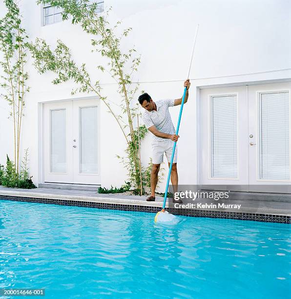 man cleaning out swimming pool - swimming pool cleaning stock pictures, royalty-free photos & images