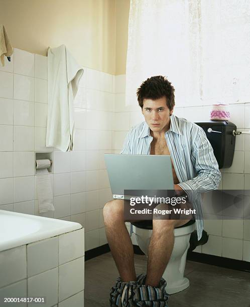 young man using lap top whilst on toilet, portrait - men taking a dump stock pictures, royalty-free photos & images