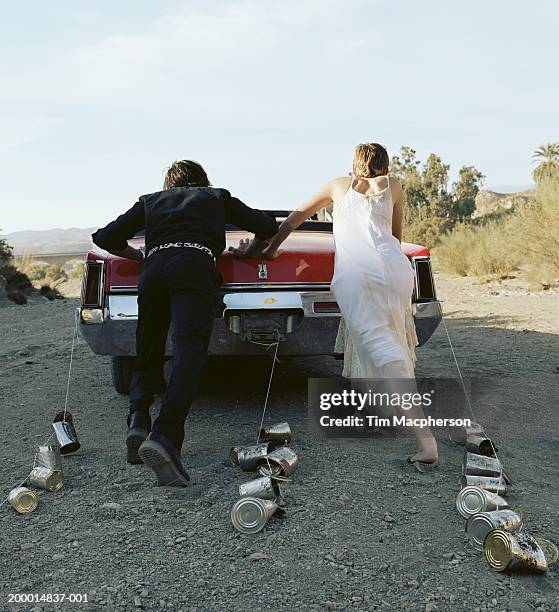 bride and groom pushing car - bride and groom wedding car stock pictures, royalty-free photos & images
