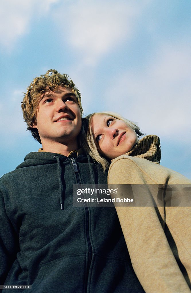 Young Couple Standing Outdoors Woman Leaning Head On Mans Shoulder High young-couple-standing-outdoors-woman-leaning-head-on-mans-shoulder-high