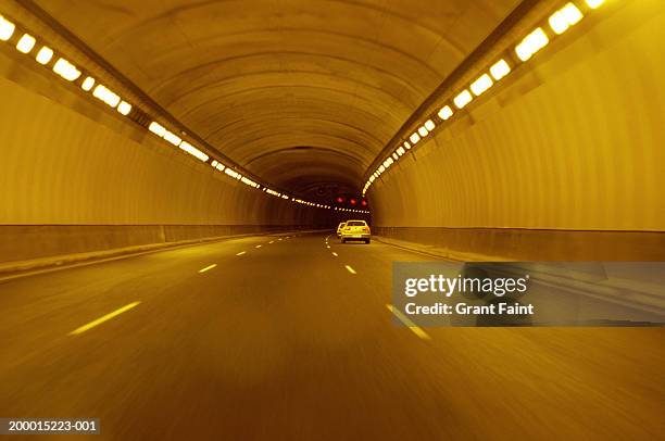 cars travelling through tunnel, rear view - túnel de carretera fotografías e imágenes de stock