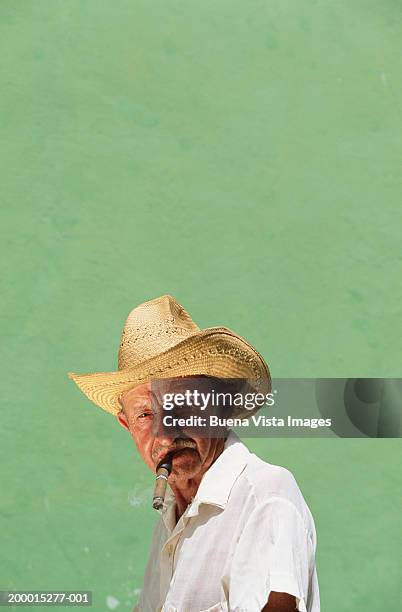 man wearing hat with cigar in mouth, portrait - cigar stock-fotos und bilder