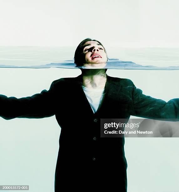 young man fully clothed in water, head above surface - survival stock pictures, royalty-free photos & images