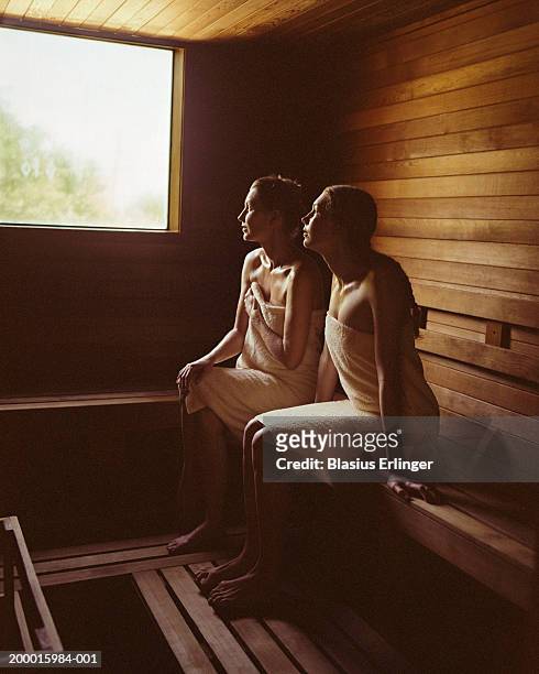 mother and teenage daughter (13-15) sitting in sauna - sauna stock-fotos und bilder