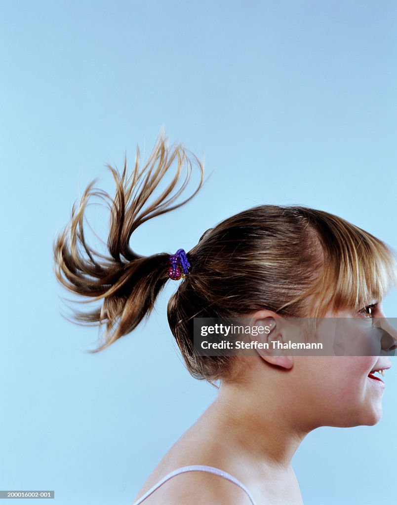 Girl (7-9) wearing hair in ponytail, profile, close-up