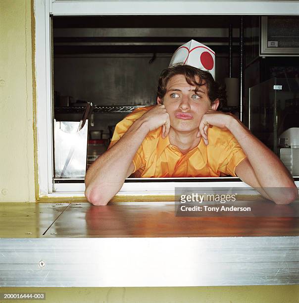 teenage boy (16-18) behind counter at hot dog stand - bored worker fotografías e imágenes de stock