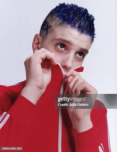 teenage boy (13-15) with blue dyed hair, zipping up sweatshirt - boy tracksuit stock pictures, royalty-free photos & images