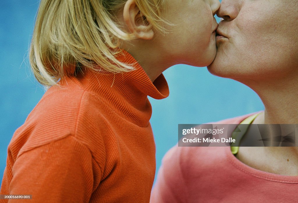 Daughter (3-5) kissing mother, close-up