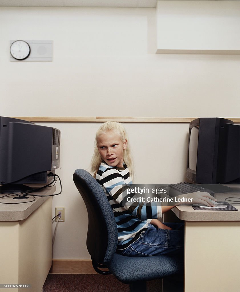 Teenage girl (13-15) in computer class, looking back