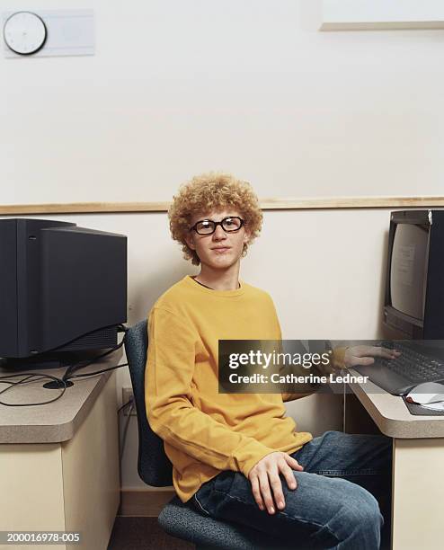 teenage boy (14-16) sitting at computer in class - nerd stockfoto's en -beelden