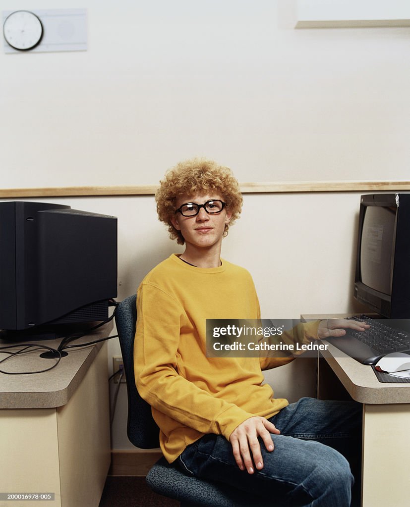 Teenage boy (14-16) sitting at computer in class