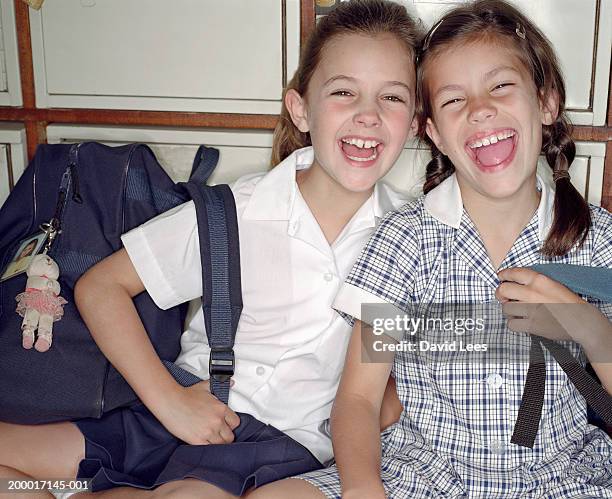 two school girls (7-9) laughing in front of lockers, portrait - enfant cartable photos et images de collection