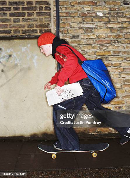 teenage paperboy (12-14) on skateboard - repartidor de periódicos fotografías e imágenes de stock