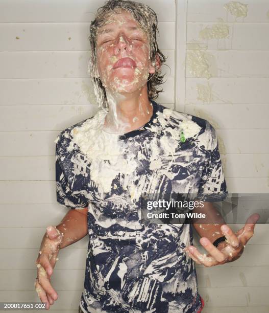 young man covered in cream licking lips, eyes closed, close-up - food fight stock pictures, royalty-free photos & images