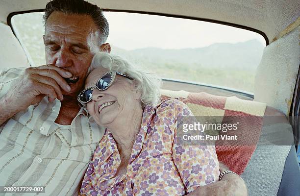 elderly couple in car, man playing harmonica, close-up - harmonica stock pictures, royalty-free photos & images