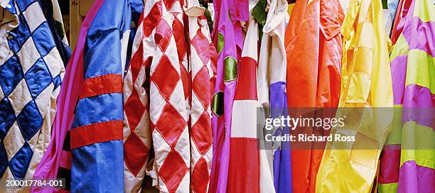 jockey's silks hanging in jockey room, close-up - horse racing stock-fotos und bilder