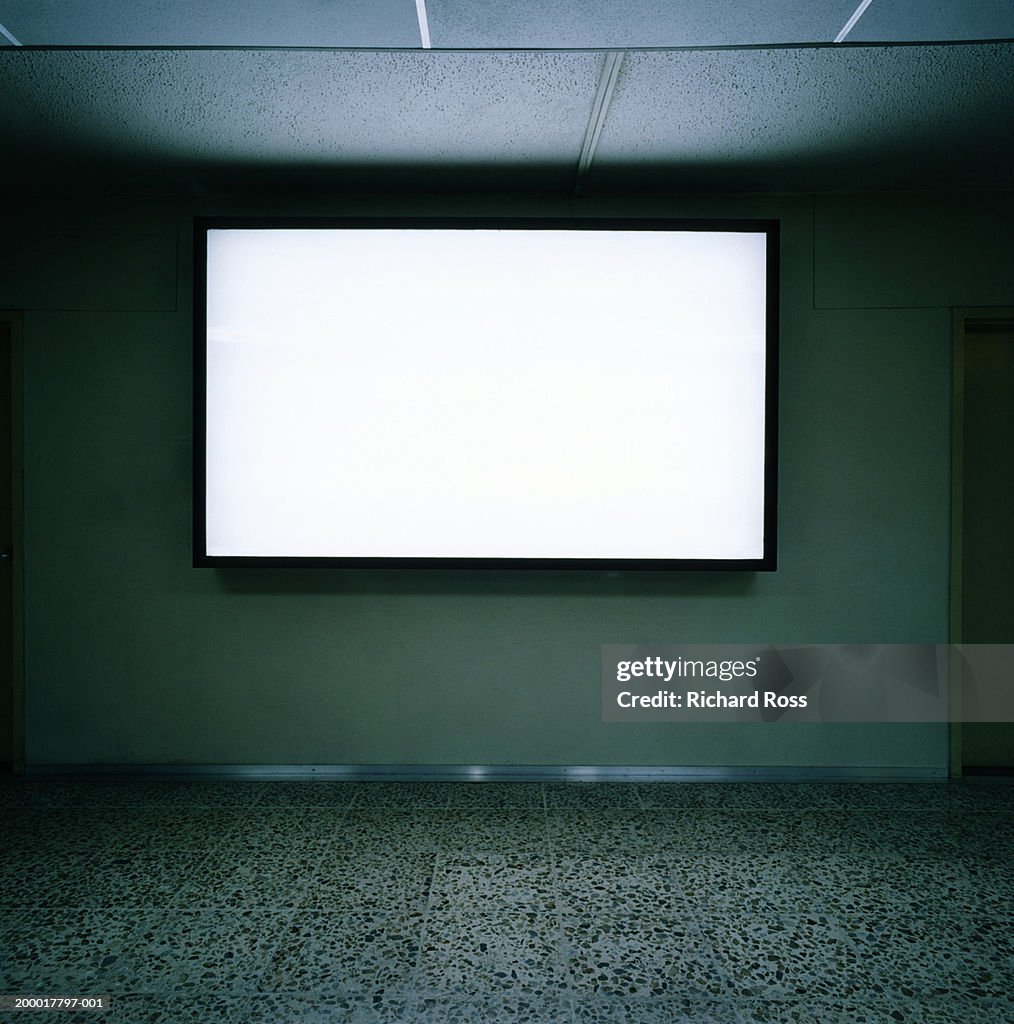 Blank screen on wall in empty room