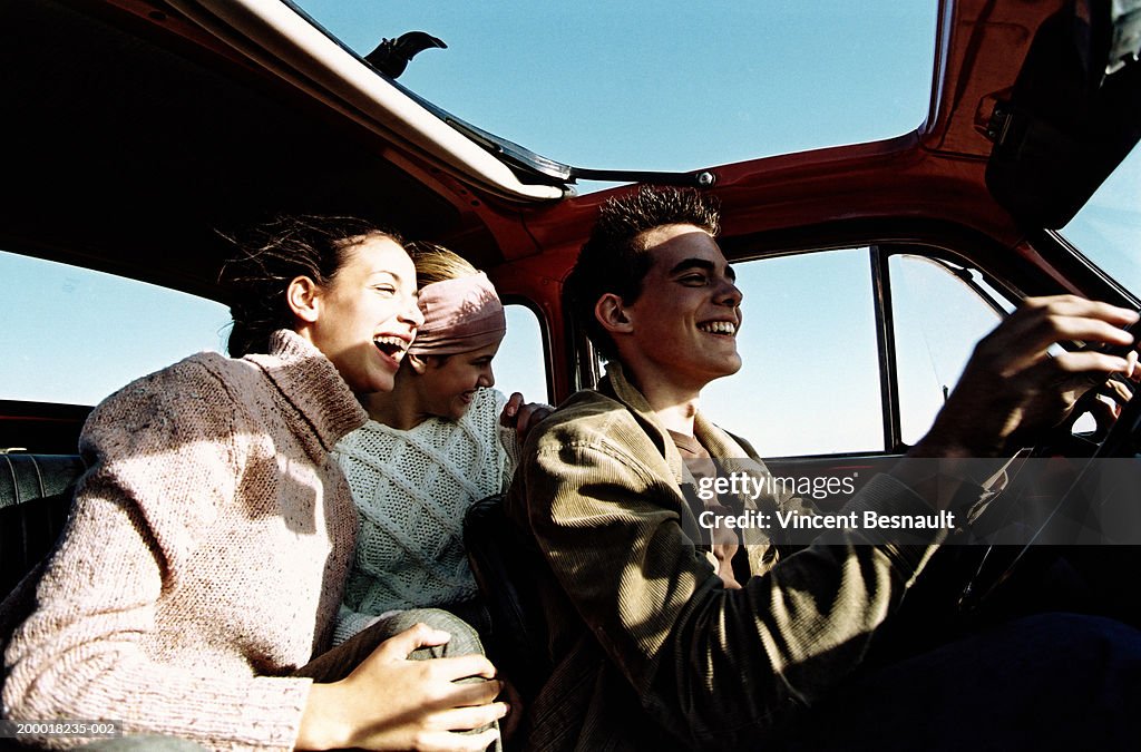 Three teenagers (14-18) in car with open sunroof