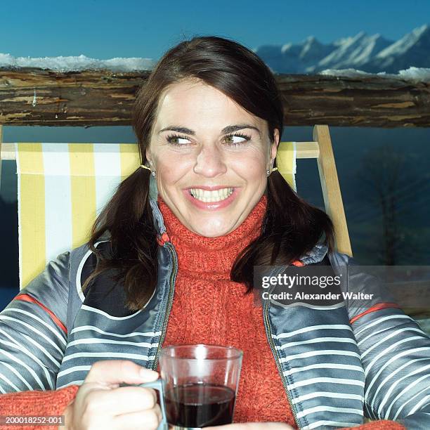 woman sitting in deckchair with hot drink, close-up - sorriso amarelo imagens e fotografias de stock