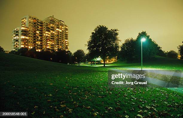 apartment building overlooking park at dusk - public park at night stock pictures, royalty-free photos & images