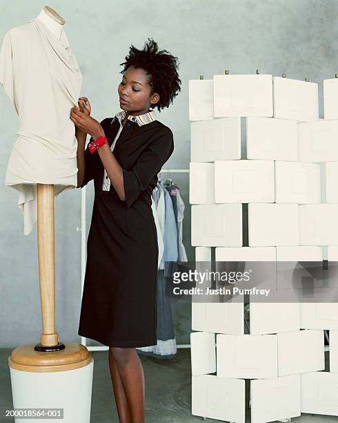 young woman pinning material together on mannequin - fashion designer fotografías e imágenes de stock