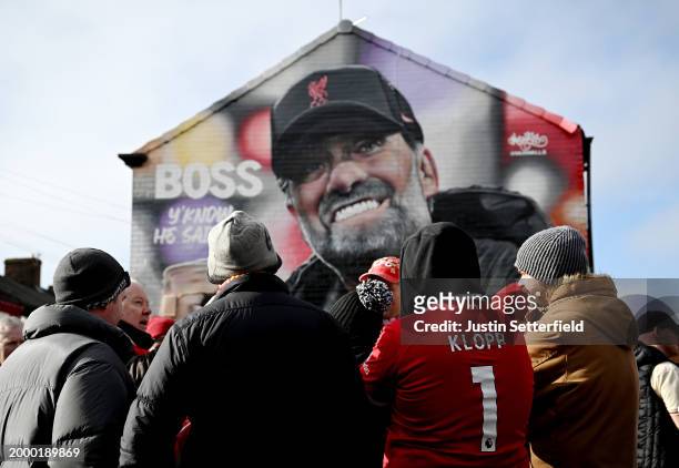 Liverpool fans look on in front of a Jurgen Klopp, Manager of Liverpool mural prior to the Premier League match between Liverpool FC and Burnley FC...